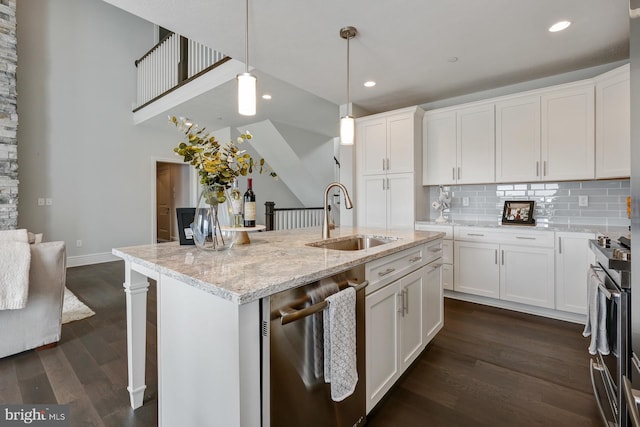 kitchen with light stone counters, sink, hanging light fixtures, and white cabinets