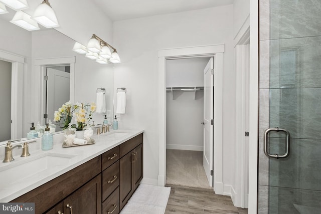 bathroom with hardwood / wood-style floors, an enclosed shower, and vanity