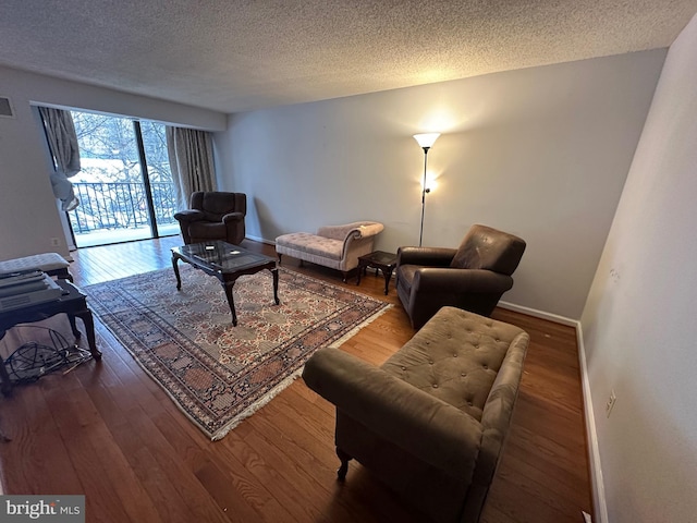 living room with wood-type flooring and a textured ceiling