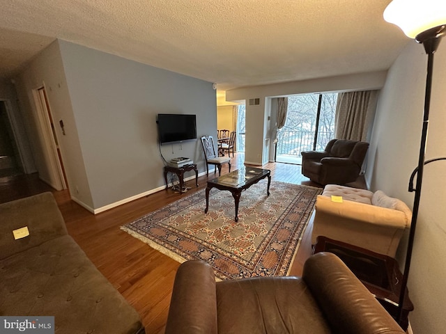 living room featuring a textured ceiling and hardwood / wood-style flooring