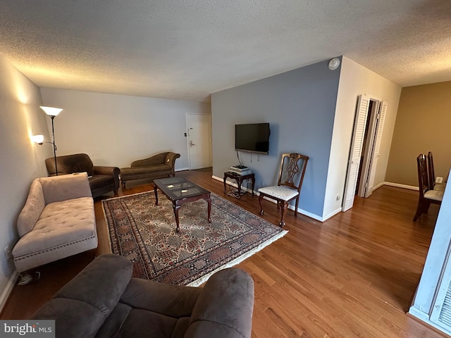 living room with a textured ceiling and hardwood / wood-style flooring