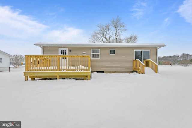 snow covered house with a deck