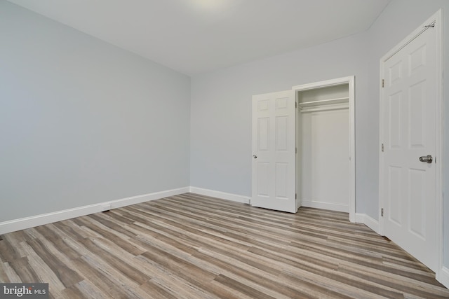 unfurnished bedroom with a closet and light hardwood / wood-style flooring