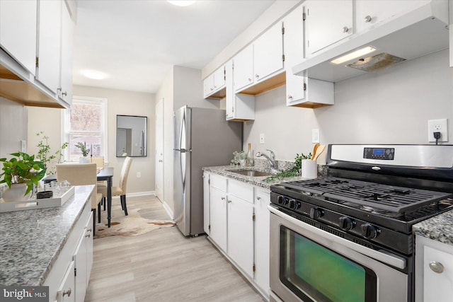 kitchen featuring sink, stainless steel appliances, white cabinetry, and light hardwood / wood-style floors