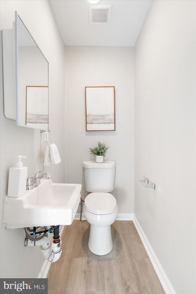 bathroom with toilet, sink, and hardwood / wood-style flooring