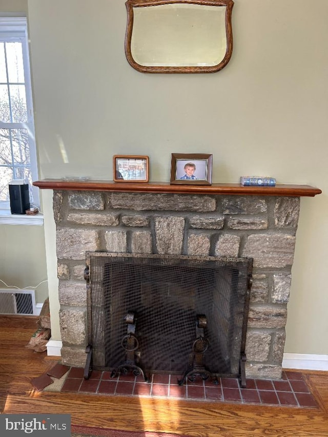 interior details featuring a fireplace and wood-type flooring