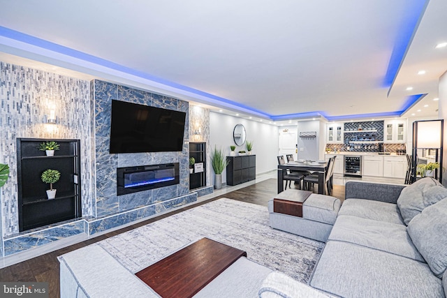 living room featuring a fireplace, dark hardwood / wood-style flooring, bar, and wine cooler