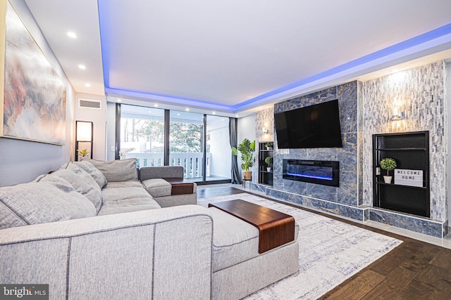 living room featuring dark hardwood / wood-style floors and a large fireplace