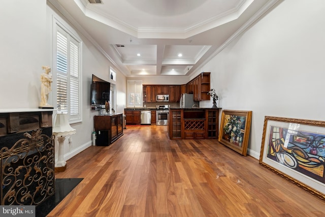 kitchen featuring stainless steel appliances, ornamental molding, and wood-type flooring