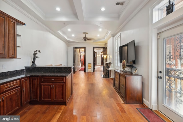 kitchen with ceiling fan, dark stone countertops, ornamental molding, and light hardwood / wood-style flooring