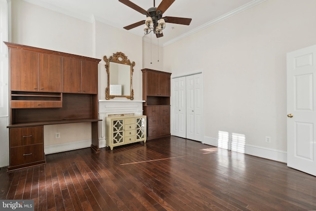 unfurnished living room featuring ceiling fan, a high ceiling, dark hardwood / wood-style floors, and crown molding