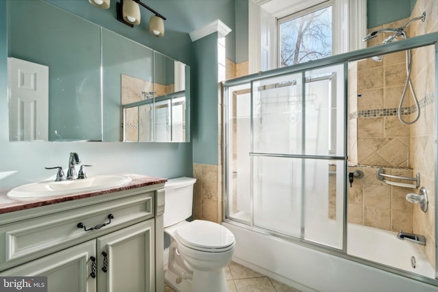 full bathroom featuring toilet, enclosed tub / shower combo, tile patterned flooring, and vanity