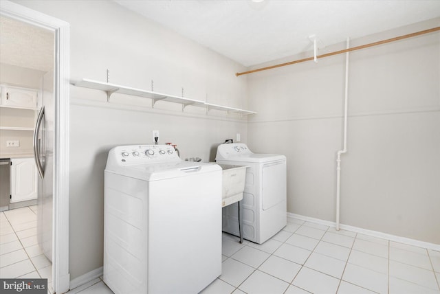 washroom featuring light tile patterned floors and washing machine and clothes dryer