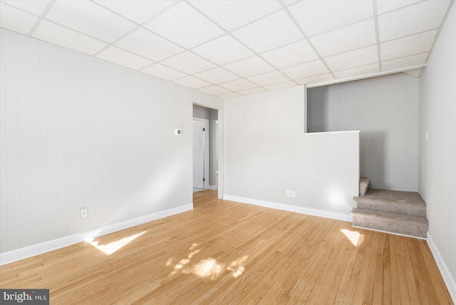 unfurnished room featuring hardwood / wood-style flooring and a drop ceiling