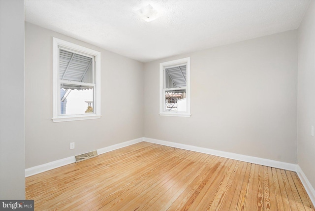 spare room with wood-type flooring and a textured ceiling