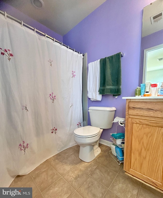 bathroom with toilet, vanity, tile patterned flooring, and walk in shower