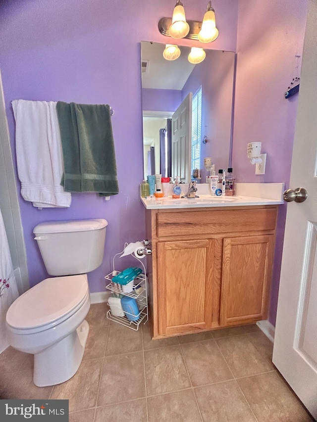 bathroom with toilet, tile patterned floors, and vanity