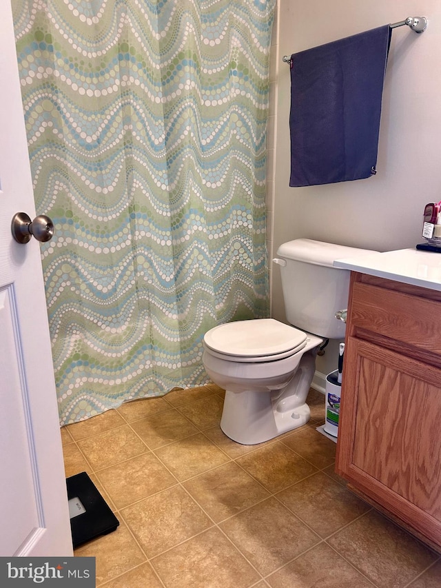 bathroom with toilet, tile patterned flooring, and vanity