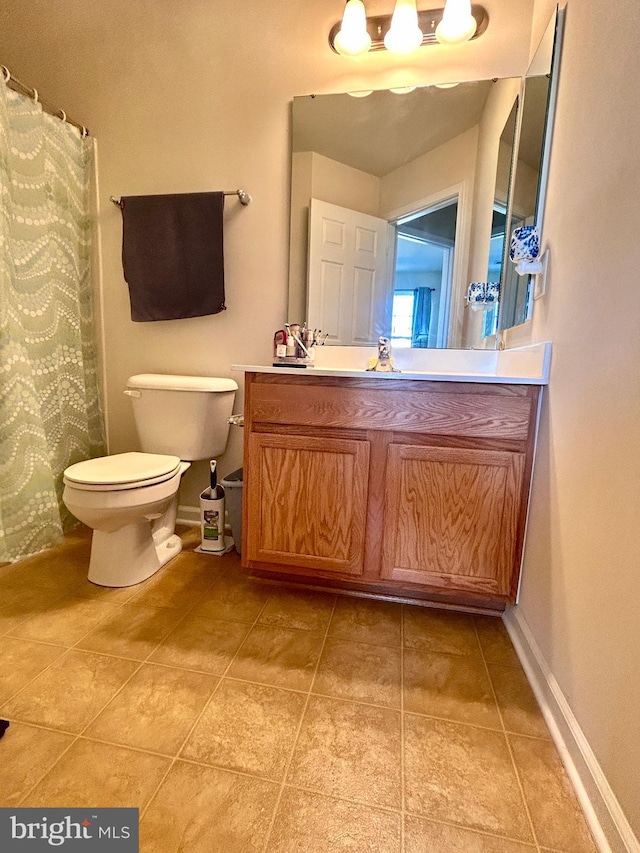 bathroom with toilet, tile patterned floors, and vanity