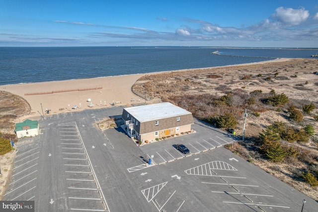 drone / aerial view with a water view and a view of the beach