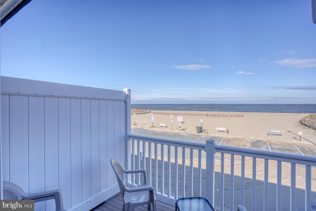 balcony featuring a water view and a view of the beach