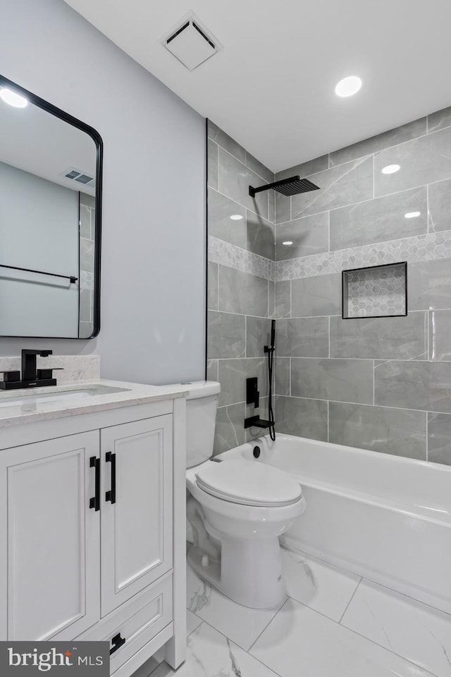 full bathroom with toilet, tiled shower / bath combo, and vanity