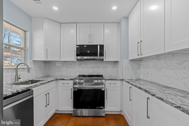 kitchen featuring sink, white cabinetry, backsplash, and stainless steel appliances