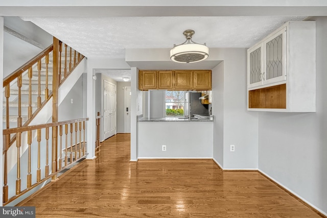 kitchen featuring hardwood / wood-style floors, a textured ceiling, and stainless steel fridge