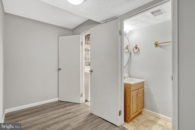 bathroom featuring wood-type flooring, a textured ceiling, and vanity