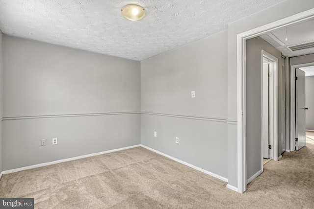 carpeted spare room with a textured ceiling