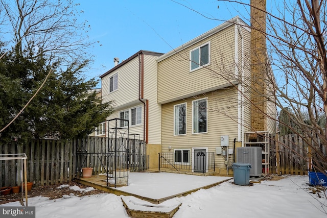 snow covered house featuring central AC