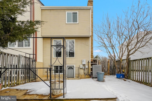 snow covered property with central AC