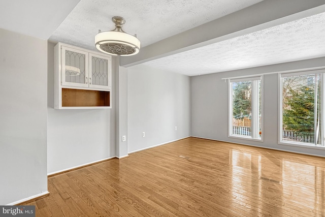 spare room with hardwood / wood-style floors and a textured ceiling