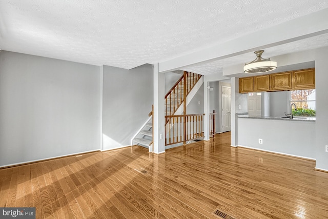 unfurnished living room with sink and a textured ceiling