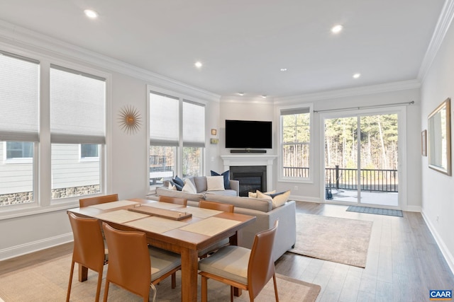 dining area featuring light wood-type flooring and crown molding