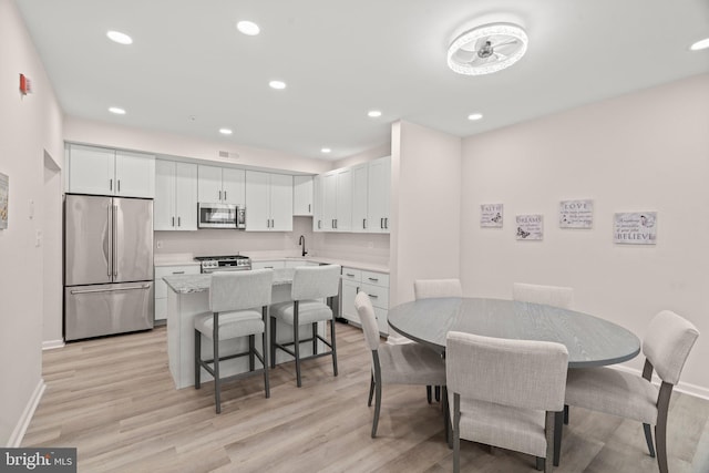 dining area with light hardwood / wood-style floors and sink