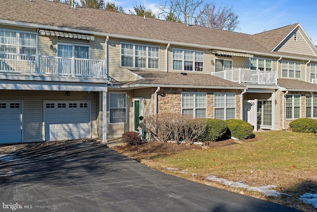 townhome / multi-family property featuring a front yard and a garage