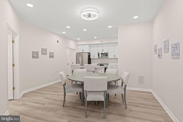 dining space with light hardwood / wood-style floors