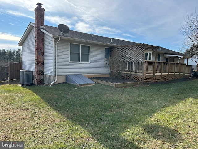 back of house featuring a wooden deck, central AC unit, and a lawn