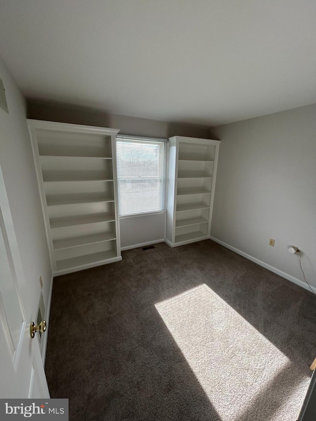 unfurnished bedroom featuring dark carpet