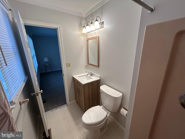 bathroom with toilet, vanity, and ornamental molding