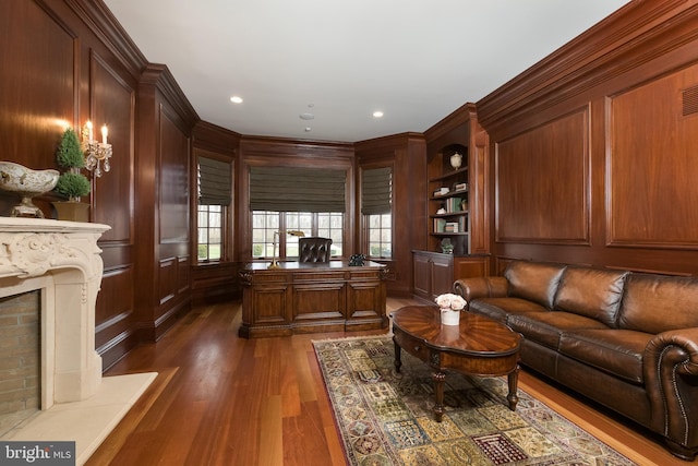 office space with a fireplace, dark hardwood / wood-style floors, and wooden walls