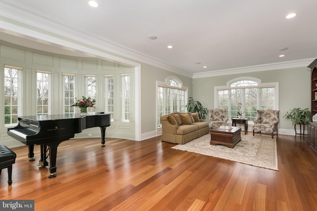 living area with ornamental molding and hardwood / wood-style flooring