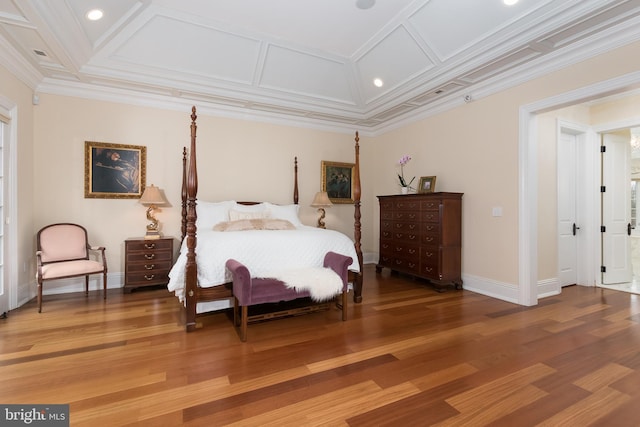 bedroom featuring hardwood / wood-style floors, crown molding, and coffered ceiling