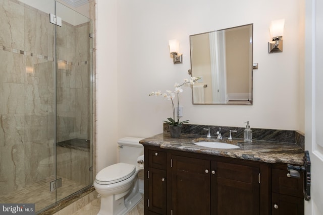 bathroom featuring a shower with shower door, toilet, and vanity