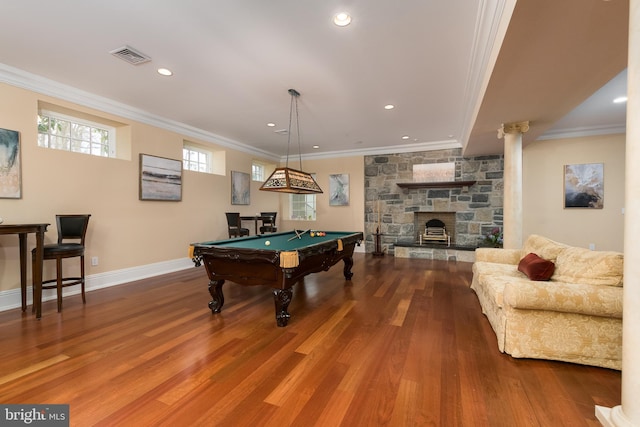 game room featuring hardwood / wood-style floors, billiards, ornamental molding, and a stone fireplace