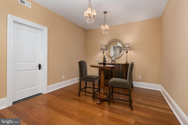 living area featuring an inviting chandelier and hardwood / wood-style flooring