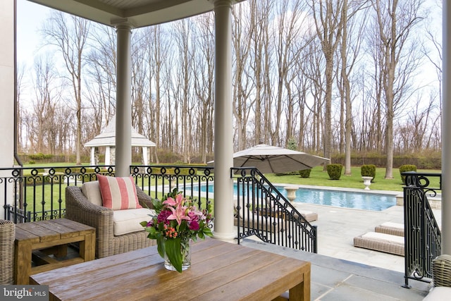 wooden terrace featuring a gazebo and a patio