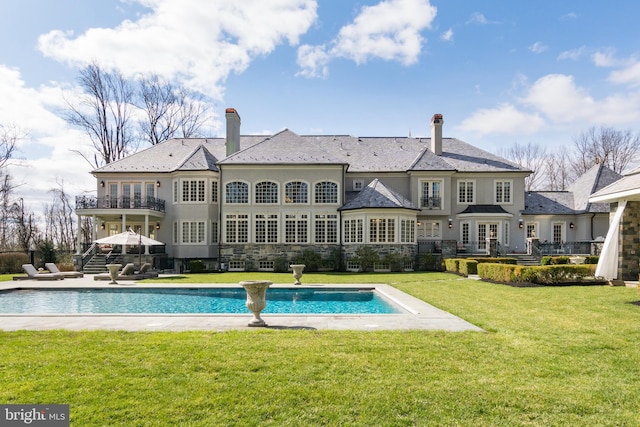 rear view of house with a lawn and a patio