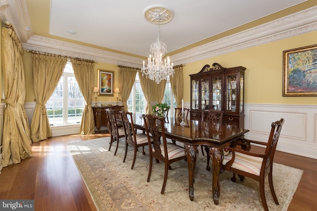 dining space with a chandelier, crown molding, and wood-type flooring